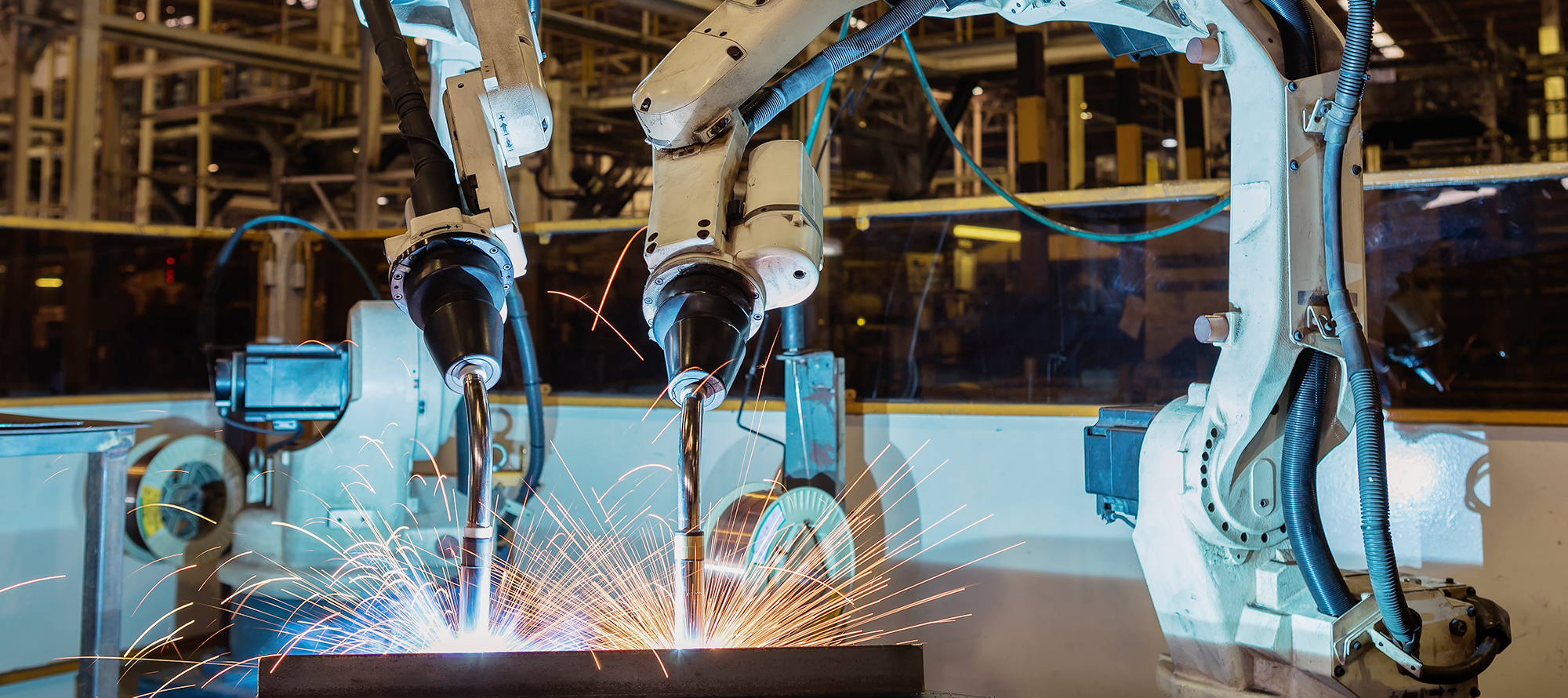 Welding robots in an industrial warehouse assembling a product